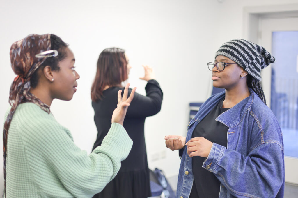 Two students communicate in British Sign Language during their BSL lesson
